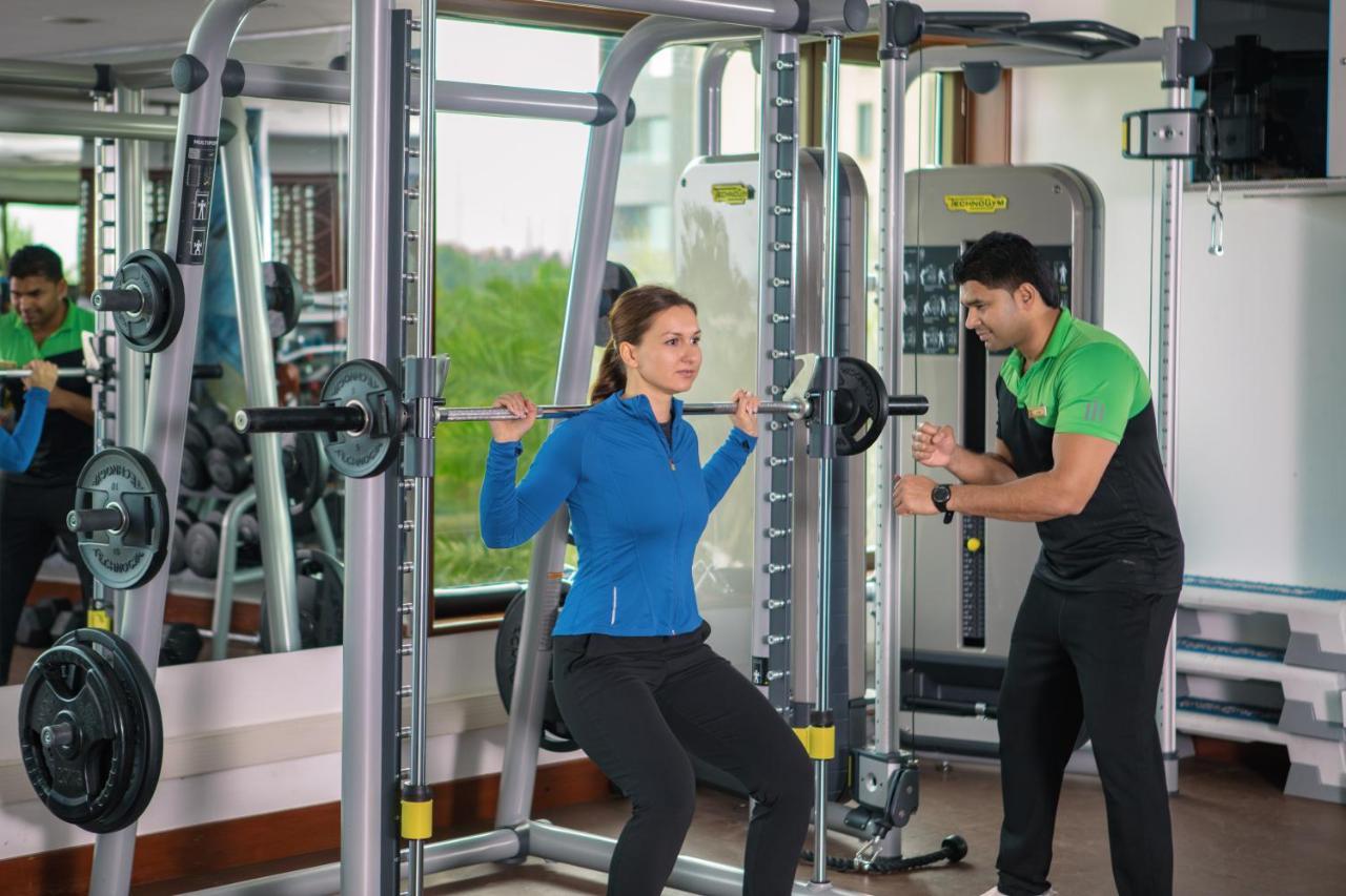 Jumeirah Messilah Beach Kuwait Kuwait City Eksteriør bilde A personal trainer assisting a woman with a squat